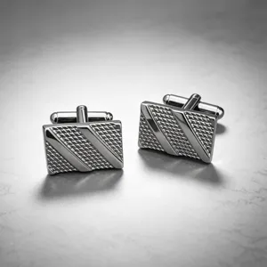 Detailed view of silver tone metallic business square cufflinks with textured diagonal patterns.