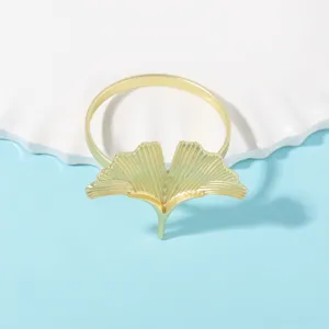 Primer plano detallado del elegante servilletero de hoja de ginkgo dorada para la mesa.