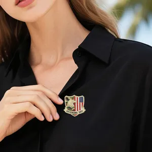 Close-up of a veteran day metal brooch pin on black shirt, detailed accessory design.