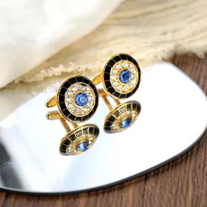 Close-up van elegante ronde Franse manchetknopen met blauwe kristal, strass en zwarte emaille.