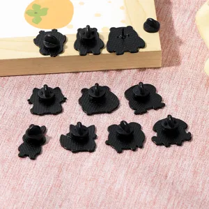 Detailed view of black metal cartoon animal brooch pin backs, cute enamel pin accessories.