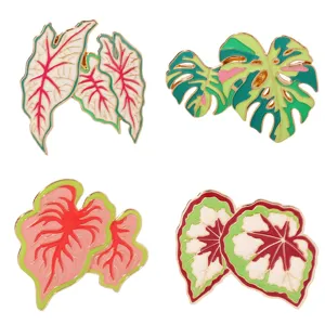 Tropical plant enamel pins detail view featuring monstera and colorful leaf designs for backpacks.