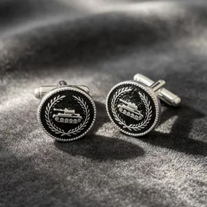 Detailed view of vintage silver tone metal men french cuff links with tank and laurel wreath motif.