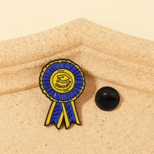 Detaillierte Nahaufnahme der blau-gelben Abschlussband-Emaillernadel mit Hut-Symbol.