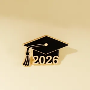 Detailaufnahme der Doktorhut-Brosche, schwarz-goldenes Emailleschild mit 2026 Design.