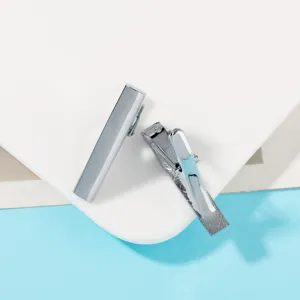 Stainless steel tie clip detail view, minimalist men business suit accessory closeup.
