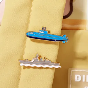 Detail view of military submarine and battleship alloy brooch badges for backpacks.