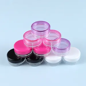 Vista dettagliata di piccoli barattoli cosmetici vuoti in plastica da 3g 5g con coperchi colorati.