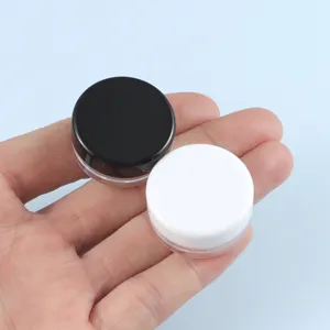 Primo piano dettaglio di piccoli barattoli per campioni cosmetici, fondo rotondo vuoti con coperchi.
