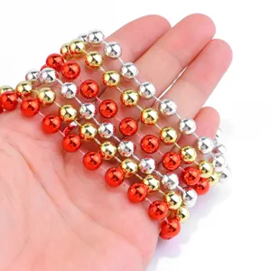 Close-up of colorful red gold silver faux pearl bead chains for DIY crafts and decor detail.