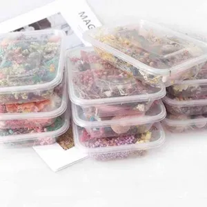 Detailed view of transparent plastic storage boxes filled with colorful DIY dried flowers.
