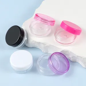 Piccoli barattoli cosmetici in plastica per crema e campioni con coperchi colorati.