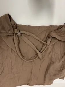 Brown cotton double gauze nursing cover detail view showing strap and ring adjustment.