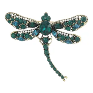 Vintage dragonfly brooch featuring sparkling green and blue crystals set in antique gold metal.