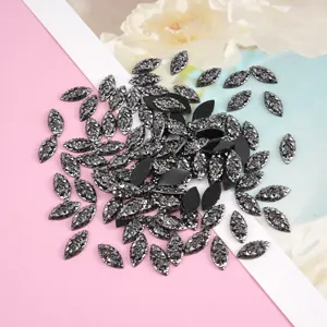Close-up detail of dark marquise resin rhinestones, sparkling faceted DIY craft accessories.