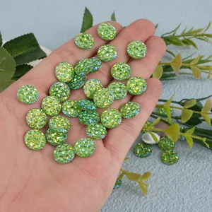 Close-up detail shot of shiny green resin rhinestone flatbacks held in hand for diy crafts.