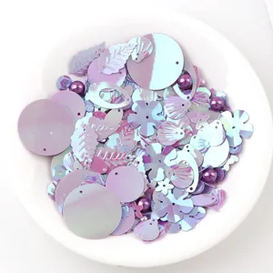Close-up detail view of colorful iridescent mixed sequins and small beads for DIY crafts and jewelry making.