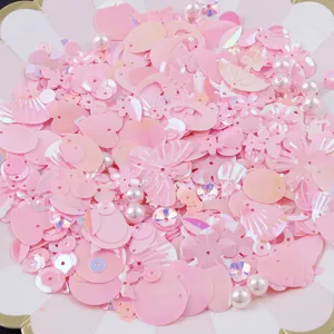 Detailed view of colorful mixed pink iridescent sequins and pearl beads for creative DIY crafts.