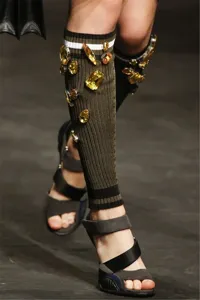 Detail view of knee high ribbed knit socks embellished with sparkling amber crystal claw rhinestones.