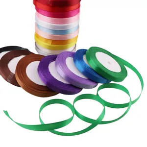 Primo piano di rotoli di nastro in raso colorato, consistenza liscia per confezioni.
