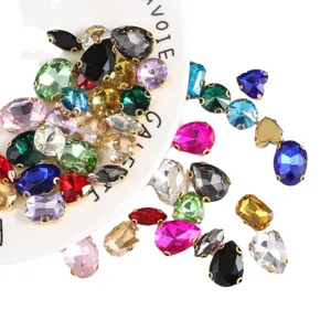 Mixed color crystal glass sew-on rhinestones with gold claw bases for DIY crafts and dresses.