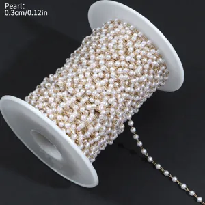 Vista detallada de cadena de perlas de 0,3cm en bobina, hilo dorado y blanco para joyas.