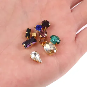 Detailed view of mixed shape glass claw rhinestones in various colors for DIY craft sewing.