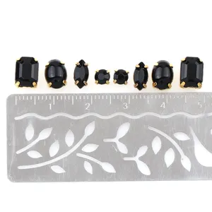 Assortiment zwarte strass-steentjes in vormen getoond met liniaal voor knutsel- en DIY-projecten.