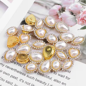 Close-up detail of gold base pearl rhinestone buttons for clothing accessories and crafts.