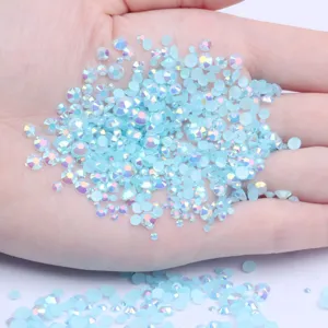 Close-up of light blue AB resin rhinestones in hand, perfect for nail art and DIY crafts.