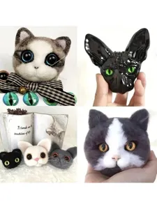 Close-up detail of handmade wool felt cat heads and colorful glass cat eyes for DIY crafts.
