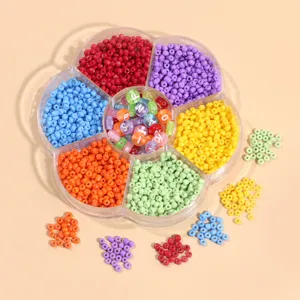 Perles de rocaille en verre de 3mm et perles alphabet en acrylique dans une boîte fleur pour DIY.