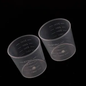Close-up detail of transparent plastic measuring cups with clear scales for resin DIY.