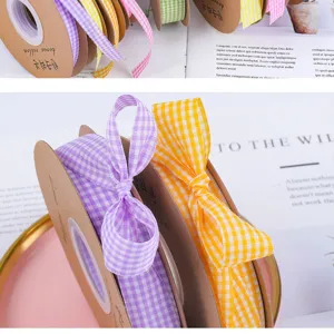 Gingham plaid fabric ribbon on paper spool for DIY gift wrapping, flower bouquet decoration.