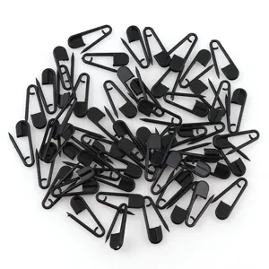Épingles de sûreté en plastique noir en vrac, vue détaillée de petites épingles.
