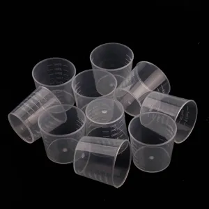 Clear plastic measuring cups detail shot for DIY epoxy resin mixing and liquid dispensing.