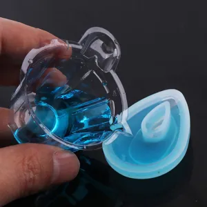 Resin mold accessory detail showing clear measuring cup pouring blue liquid into silicone mold.