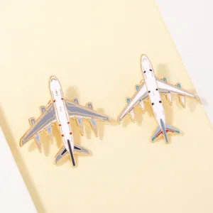 Detailed shot of two metal airplane enamel pins, stylish backpack and clothing accessories.