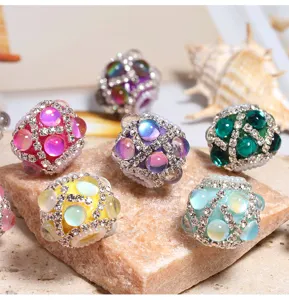 Primo piano di perline acriliche con strass sirena scintillanti, parti colorate.