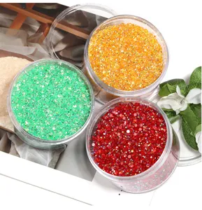 Close-up of colorful resin flatback rhinestones in transparent boxes for nail art and DIY crafts.
