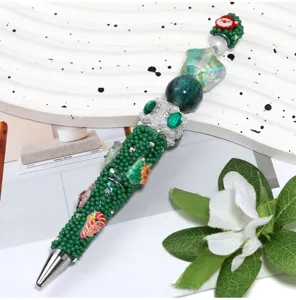Christmas DIY beaded pen with green pearls, santa charms and metallic tip for holiday.