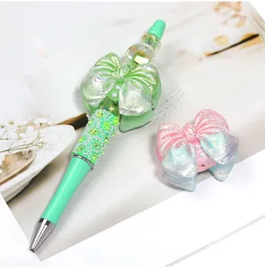 Gros plan sur les superbes détails du stylo de perles scintillant et de son charmant nœud.