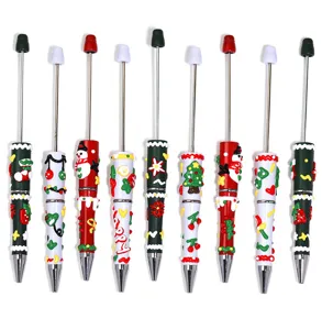 Close-up detail of cute Christmas theme ballpoint pens with cartoon snowman and tree decor.