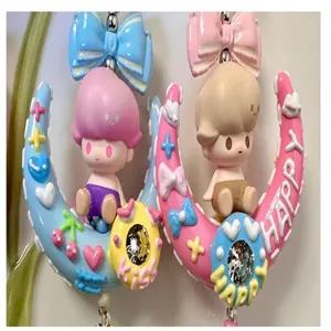 Detailed close-up of cute cartoon crescent moon charm with bow and rhinestones for DIY art.