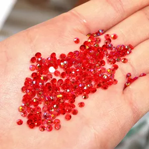 Red resin flatback rhinestones displayed on hand for nail art and DIY craft projects.