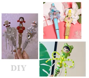 Λεπτομέρεια από χειροποίητα στυλό χάντρες DIY με αστραφτερά στρας και χαριτωμένες φιγούρες.