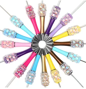 Nahaufnahme kreativer DIY-Perlenkugelschreiber mit funkelnden Diamant- und Perlendekorationen.