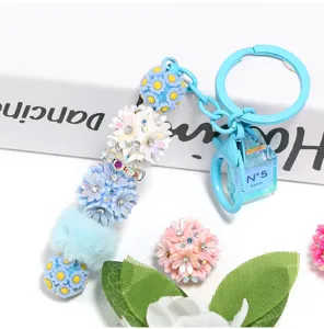 Detailed view of rhinestone flower phone charm keychain with cute resin beads and mini perfume pendant.