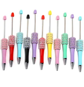 Detail view of DIY beadable ballpoint pens featuring colorful pearls and sparkling rhinestones.