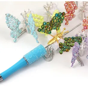 Detailed close-up shot of sparkling rhinestone butterfly pen and colorful DIY accessories.